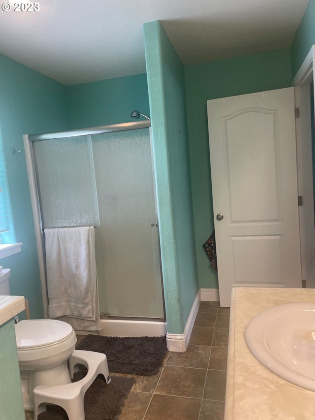 bathroom with an enclosed shower, toilet, vanity, and tile flooring