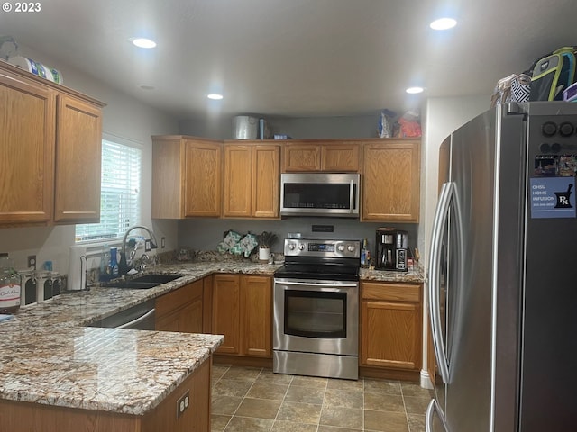 kitchen featuring light stone counters, stainless steel appliances, kitchen peninsula, sink, and light tile flooring