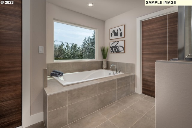 bathroom with tile patterned floors and a relaxing tiled tub