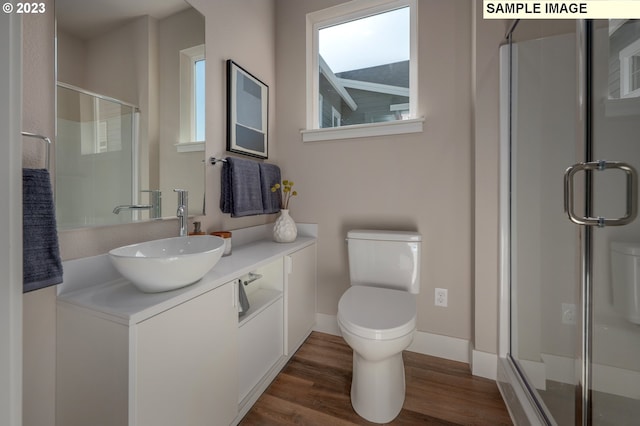 bathroom with toilet, vanity, hardwood / wood-style floors, and walk in shower