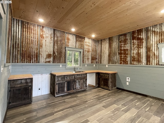 kitchen featuring wood finished floors, recessed lighting, a sink, dark brown cabinets, and wooden ceiling