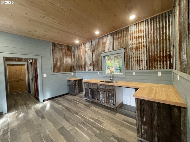 kitchen with wooden ceiling, wood finished floors, wooden counters, and a sink