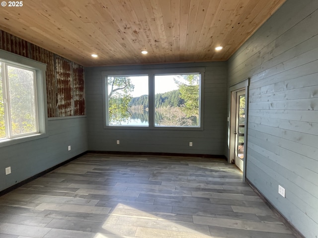 unfurnished room with wooden walls, recessed lighting, wood ceiling, and wood finished floors