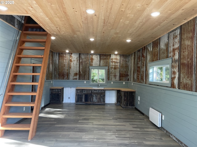 kitchen featuring wood finished floors, recessed lighting, a sink, wood walls, and wooden ceiling