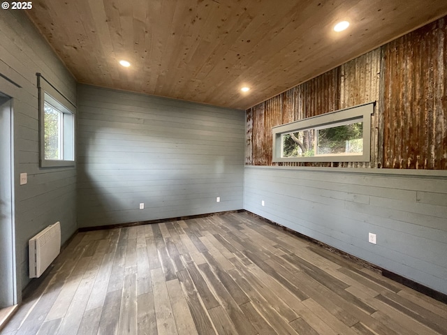 unfurnished room featuring wood finished floors, recessed lighting, wood ceiling, and wood walls