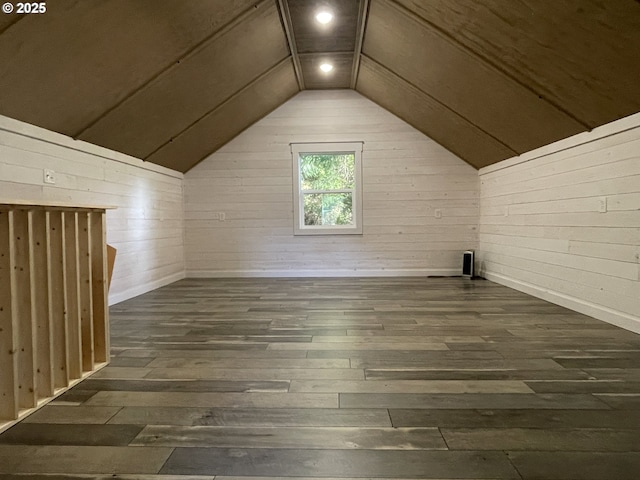 additional living space featuring lofted ceiling, dark wood-style flooring, and wood walls