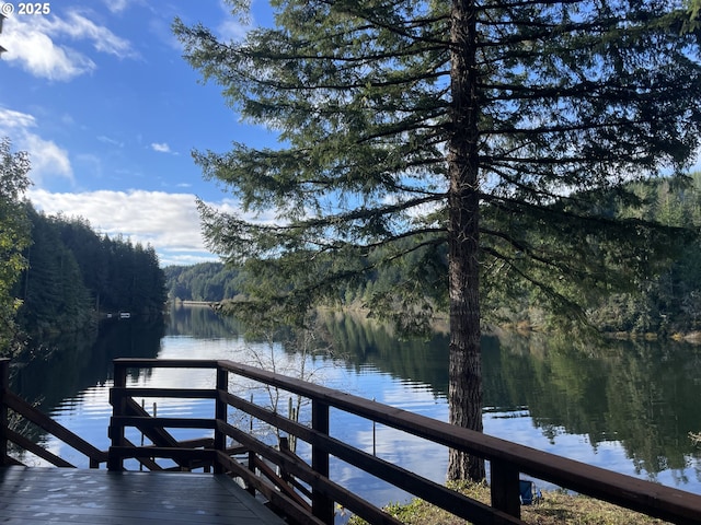 view of dock featuring a forest view and a water view