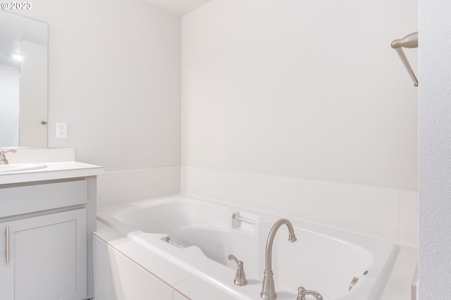 bathroom featuring vanity and tiled bath