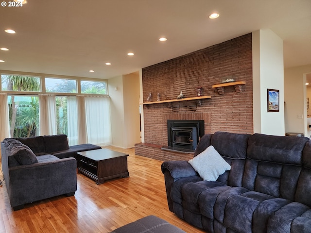 living area with light wood-style floors, recessed lighting, and a wood stove