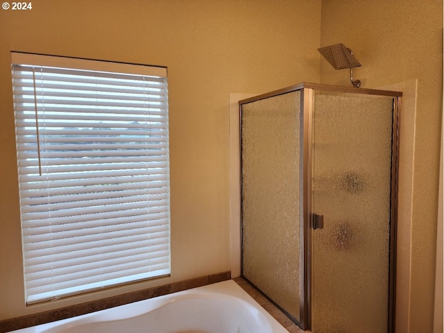 bathroom with a stall shower and a bath