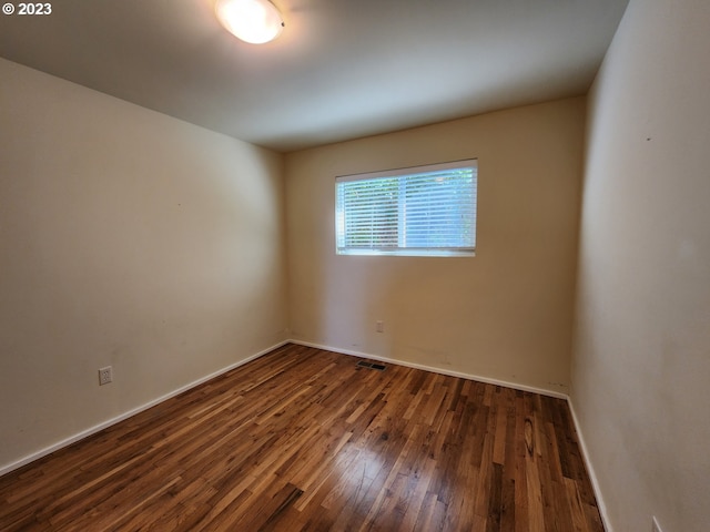 unfurnished room featuring baseboards and wood-type flooring