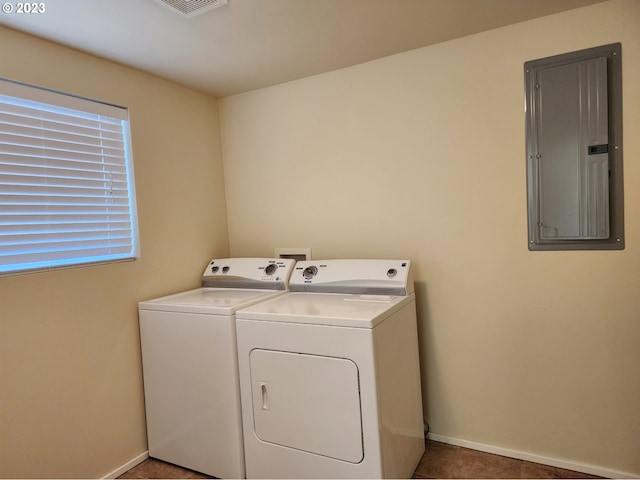 laundry area featuring baseboards, tile patterned floors, electric panel, washing machine and clothes dryer, and laundry area