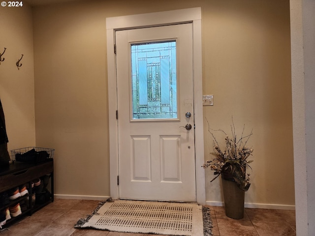 doorway featuring baseboards and tile patterned floors