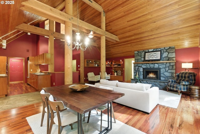 25901 E Highview Dr, Welches, OR 97067 - dining room featuring a fireplace, light wood-style flooring, high vaulted ceiling, and a wooden ceiling with exposed beams