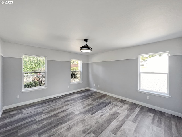 unfurnished room with dark hardwood / wood-style flooring