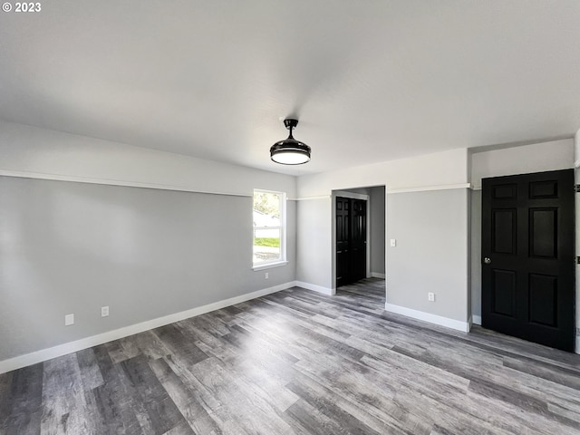 unfurnished room with dark hardwood / wood-style flooring