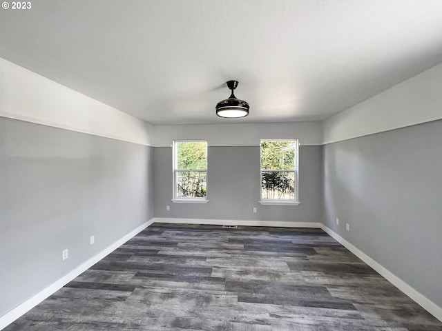 empty room with dark hardwood / wood-style flooring and ceiling fan