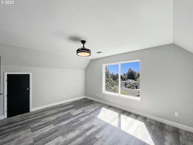 spare room featuring lofted ceiling and dark hardwood / wood-style floors