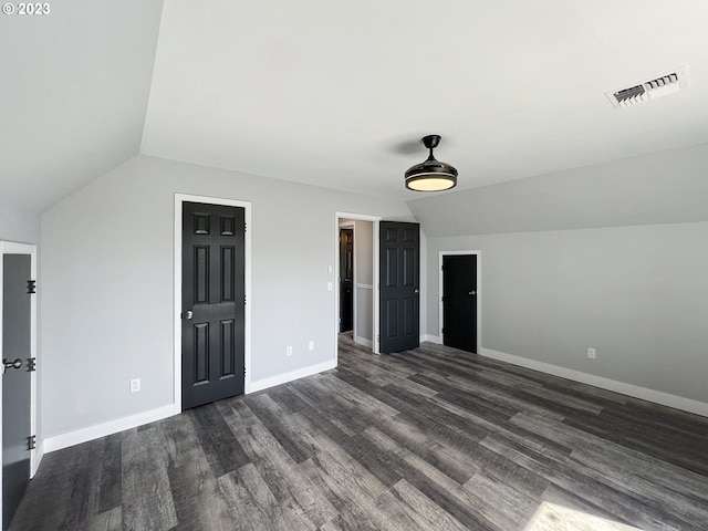 unfurnished room featuring dark hardwood / wood-style floors and vaulted ceiling