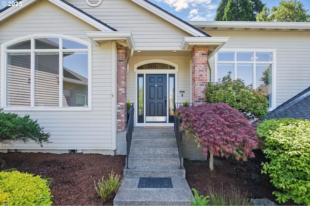 entrance to property featuring brick siding