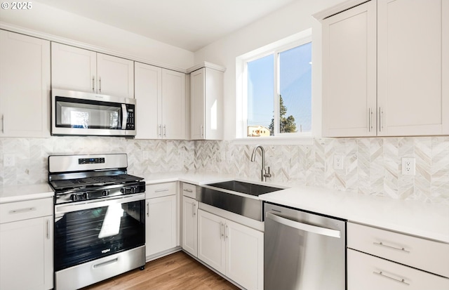 27298 SW Marigold Ter, Wilsonville, OR 97070 - kitchen with stainless steel appliances, white cabinetry, sink, and tasteful backsplash