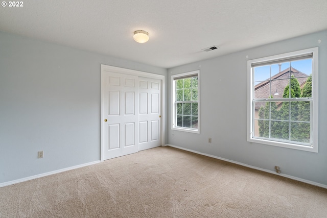 unfurnished bedroom with a closet, a textured ceiling, and carpet flooring