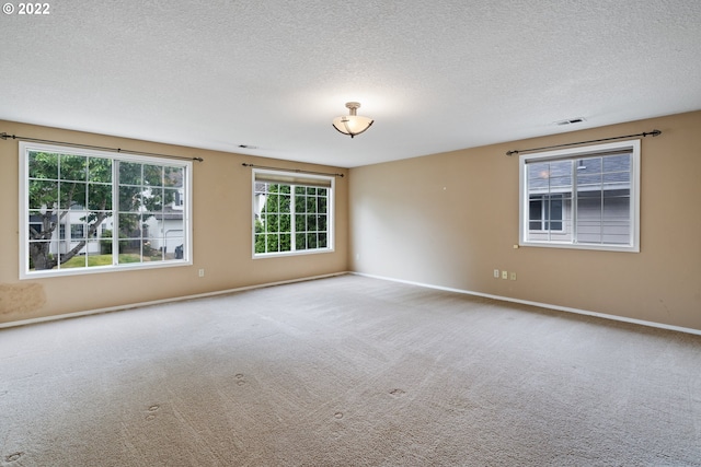 carpeted spare room with a textured ceiling