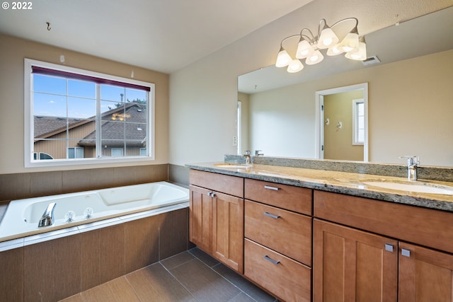 bathroom featuring vanity, a relaxing tiled tub, and tile patterned floors