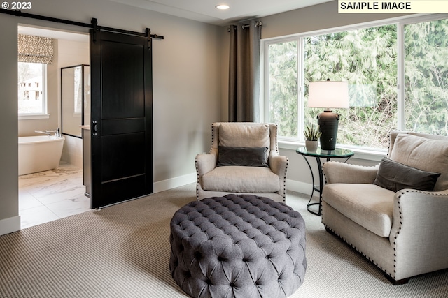 living area featuring a barn door, a wealth of natural light, and light tile floors