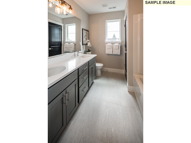 full bathroom with toilet, bathtub / shower combination, oversized vanity, dual sinks, and tile floors