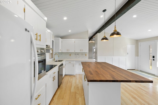 kitchen featuring vaulted ceiling with beams, light wood-style flooring, wood counters, white cabinets, and appliances with stainless steel finishes