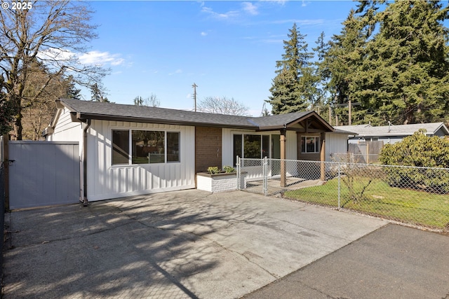 single story home featuring roof with shingles, a gate, fence, and a front yard