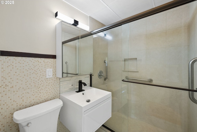 full bathroom featuring toilet, a shower stall, tile walls, and vanity