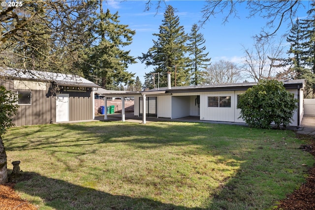 back of property featuring a lawn and an outdoor structure