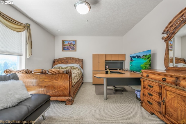 bedroom featuring a textured ceiling and light colored carpet