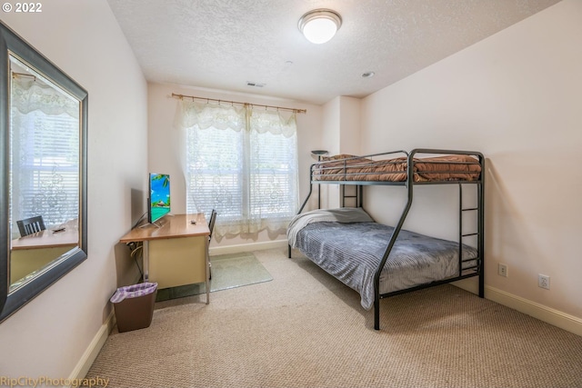 carpeted bedroom featuring a textured ceiling