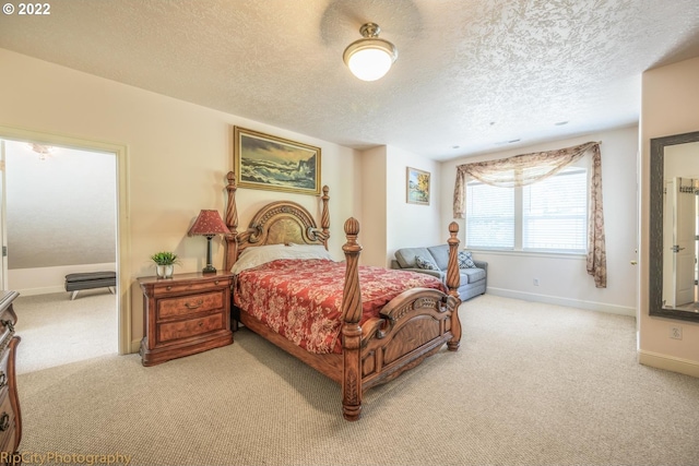 bedroom with a textured ceiling and light colored carpet