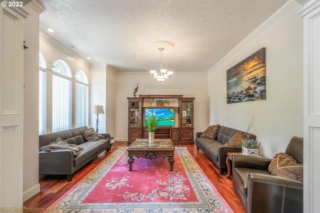 living room featuring a notable chandelier, ornamental molding, dark hardwood / wood-style floors, and a textured ceiling