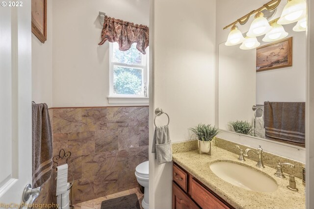 bathroom featuring toilet, vanity, and tile flooring