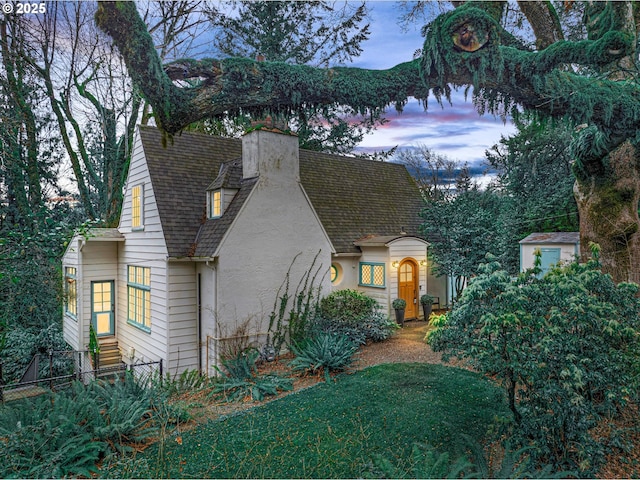 3045 SW Gaston Ave, Portland, OR 97239 - view of front of house featuring stucco siding, a chimney, and roof with shingles
