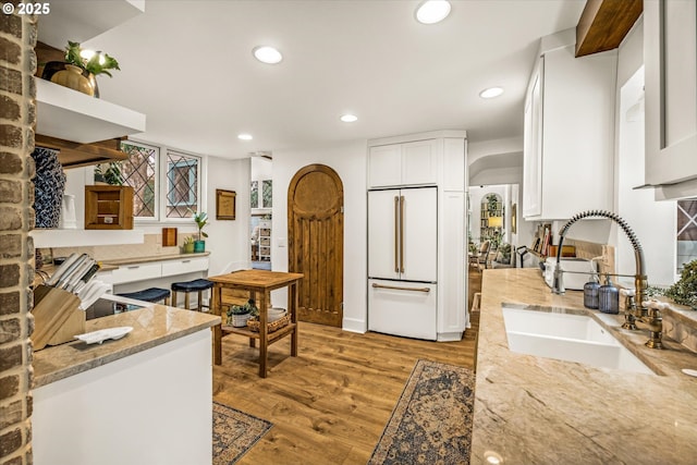 3045 SW Gaston Ave, Portland, OR 97239 - kitchen with white built in refrigerator, a sink, light stone countertops, white cabinetry, and recessed lighting