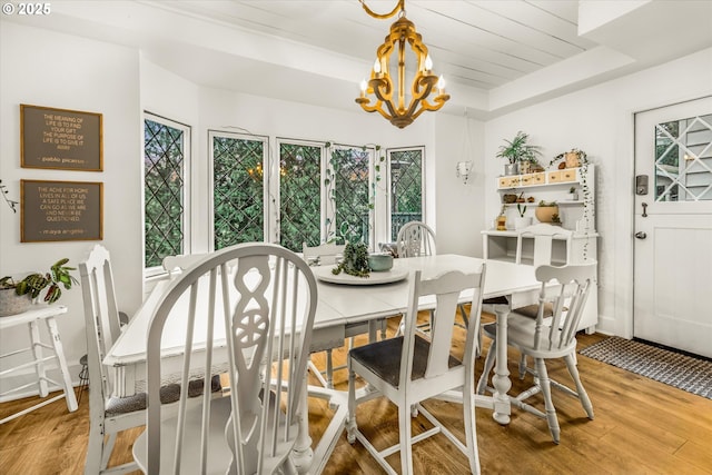3045 SW Gaston Ave, Portland, OR 97239 - dining area featuring a chandelier, wood finished floors, and a raised ceiling