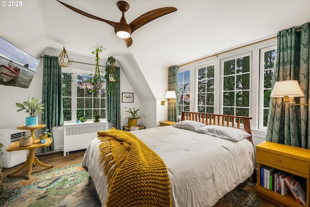 3045 SW Gaston Ave, Portland, OR 97239 - bedroom featuring radiator heating unit, wood finished floors, lofted ceiling, and ceiling fan