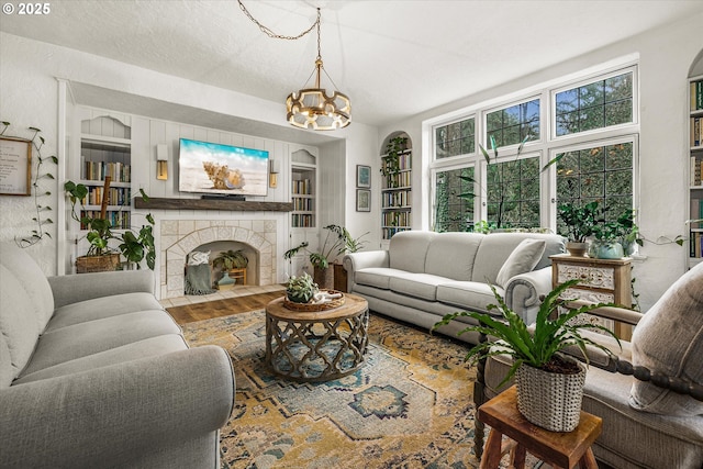 3045 SW Gaston Ave, Portland, OR 97239 - living area featuring a chandelier, wood finished floors, built in features, and a fireplace