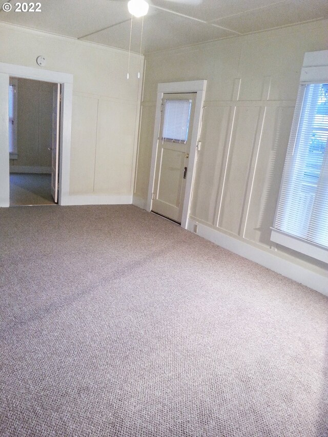 carpeted spare room with ceiling fan