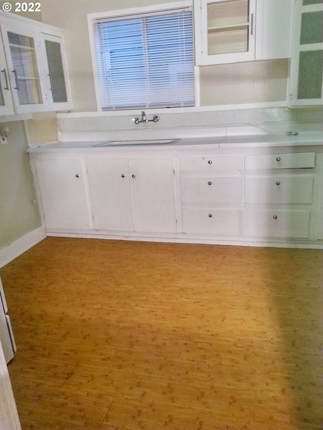 kitchen featuring light hardwood / wood-style flooring, sink, and white cabinetry