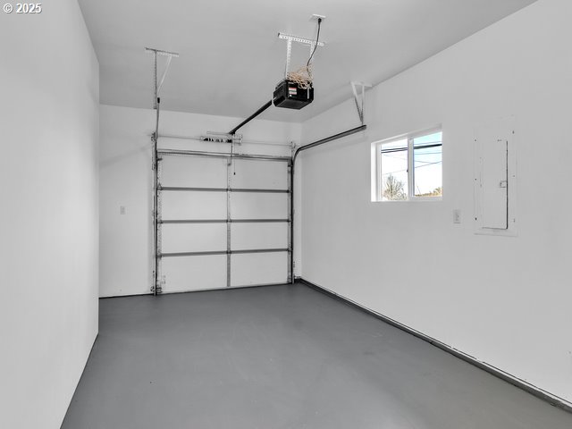 garage with a garage door opener and electric panel