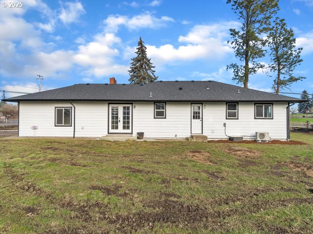 rear view of property featuring a yard and french doors