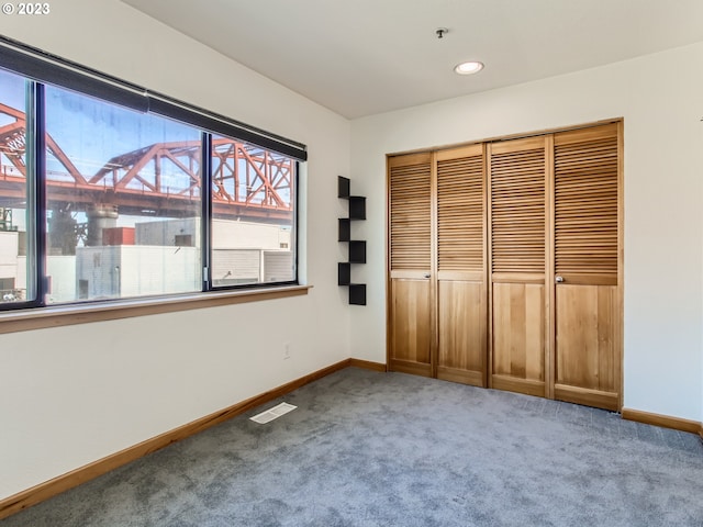 unfurnished bedroom featuring light carpet and a closet