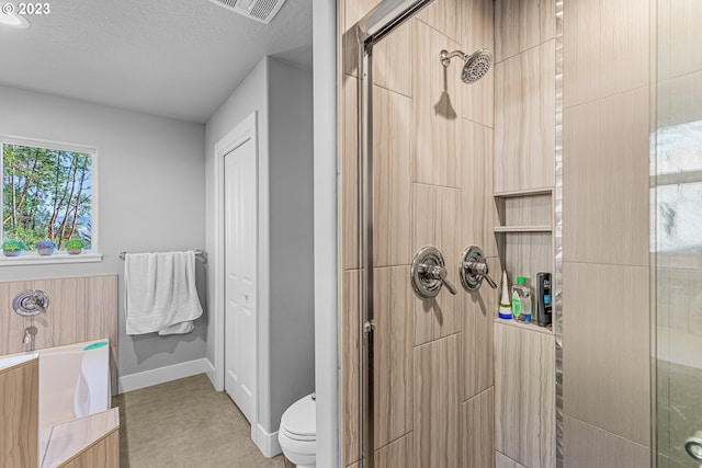 bathroom with a textured ceiling, tile floors, toilet, and separate shower and tub